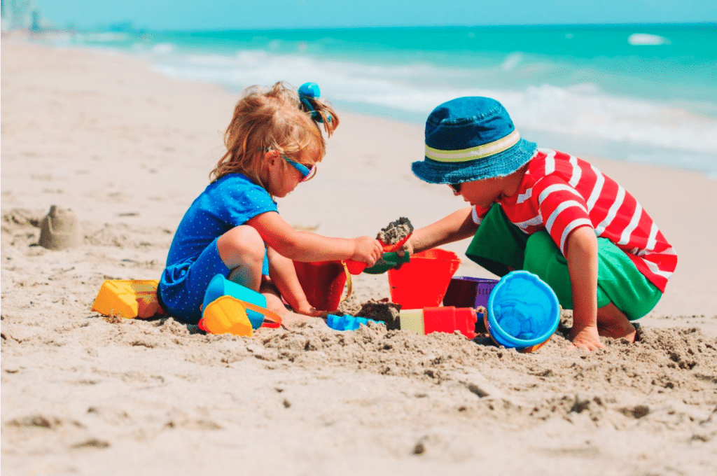 Deux enfants en vacances jouant dans le sable sur la plage.