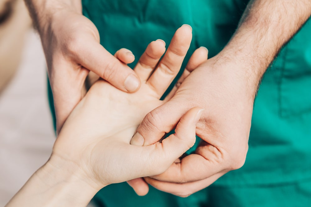 Une infirmière réconforte une future maman patiente en lui tenant la main.