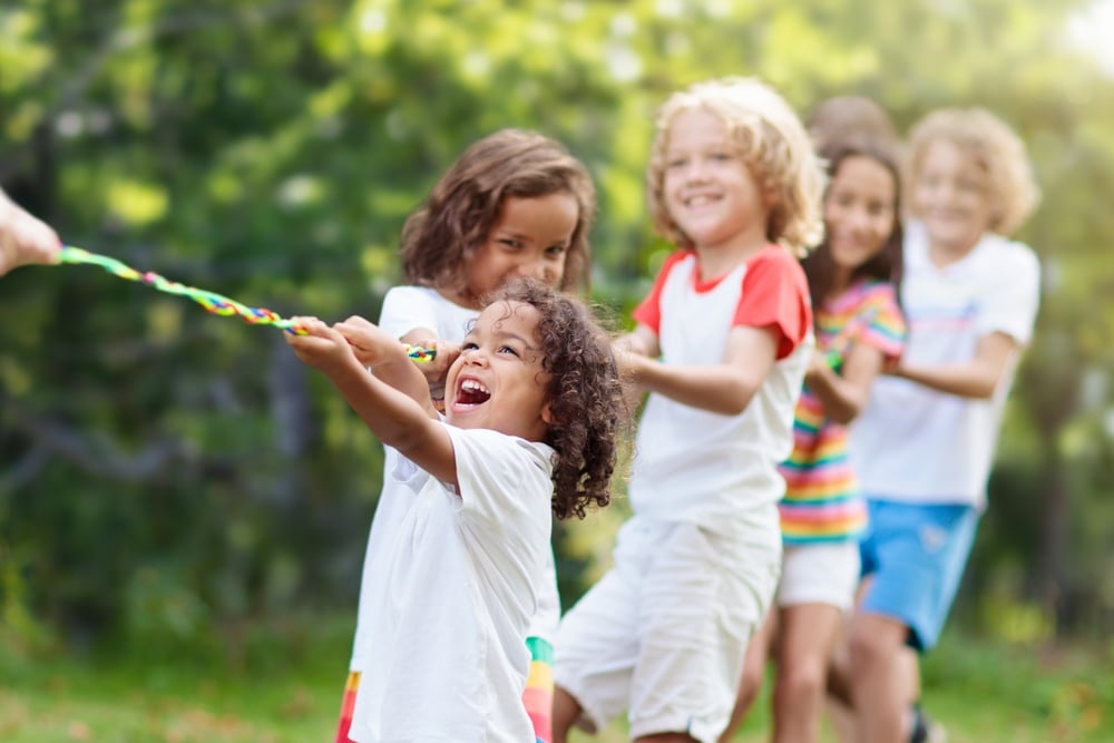 Un groupe d'enfants jouant avec une corde dans un parc pour un anniversaire inoubliable.