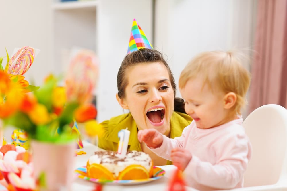 Une femme et un bébé lors d'une fête d'anniversaire.