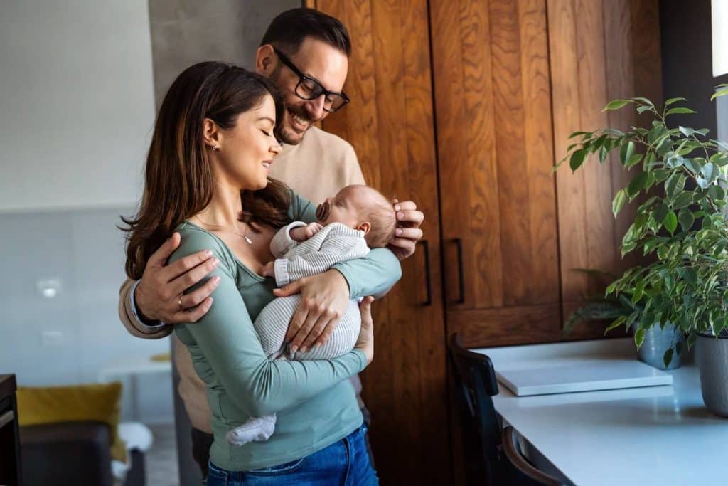 Un couple berçant amoureusement leur bébé à la maison après l'accouchement.